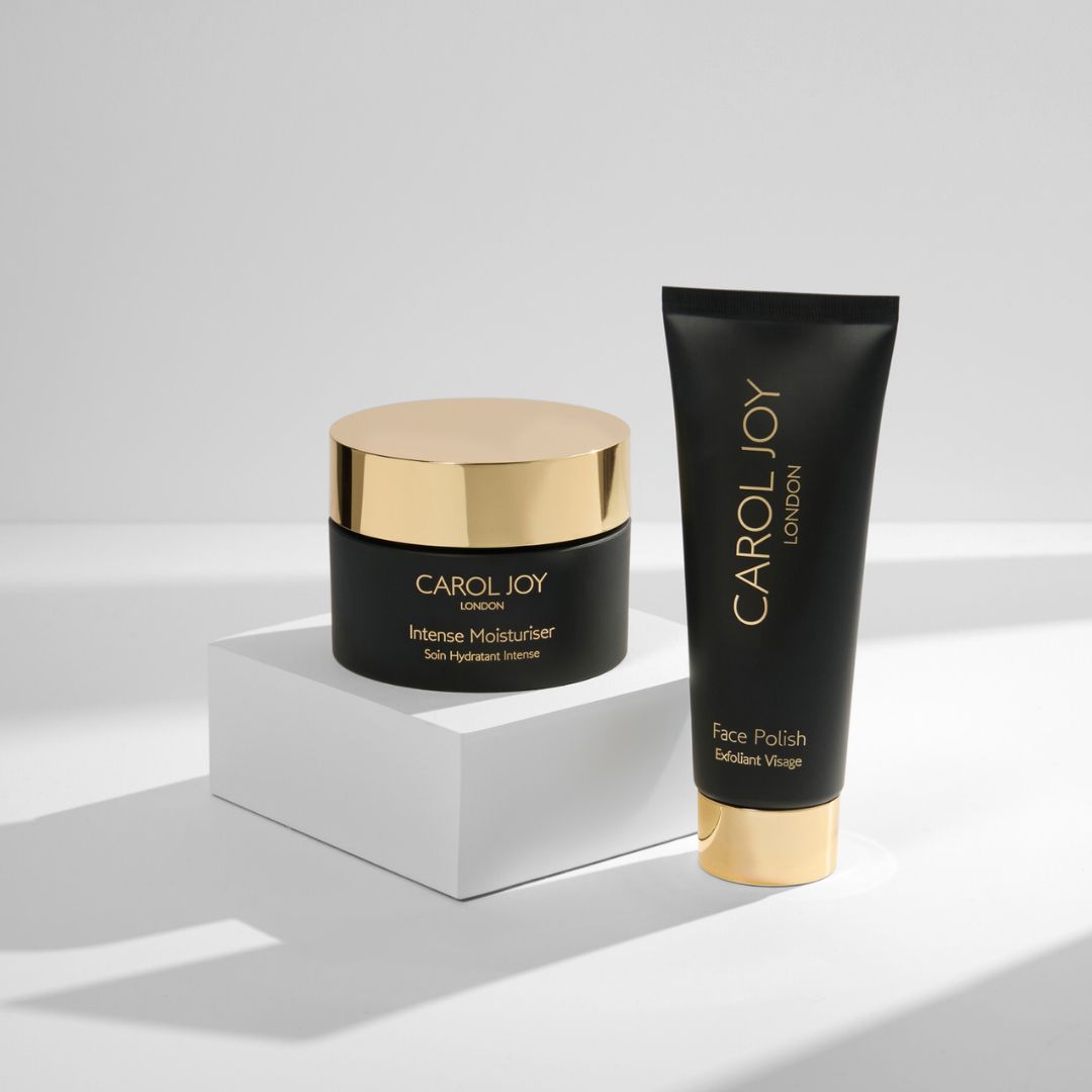 The Carol Joy London Intense Moisturiser on a display stand against a plain white background, the Carol Joy London Face Polish to its right
